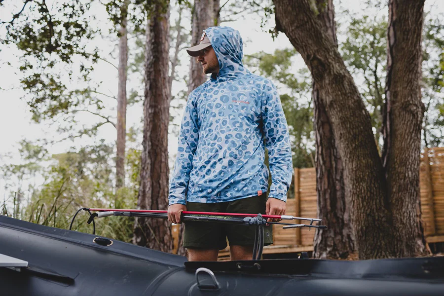 Eight shirts arranged on table in black, olive, grey, blue, white, red, mustard, and green.